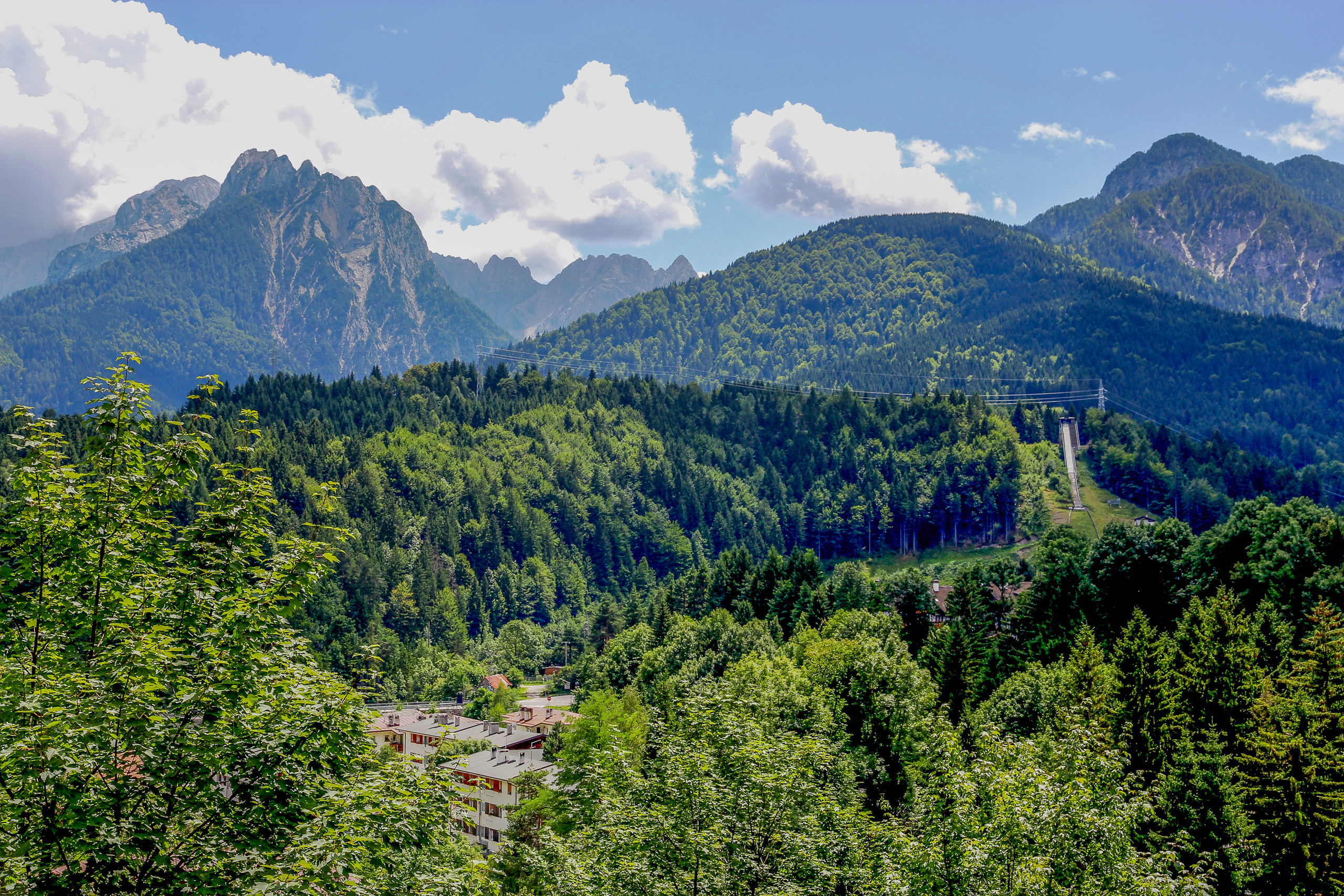 Über den bewaldeten Hängen die schroffen Zacken der Grenzberge